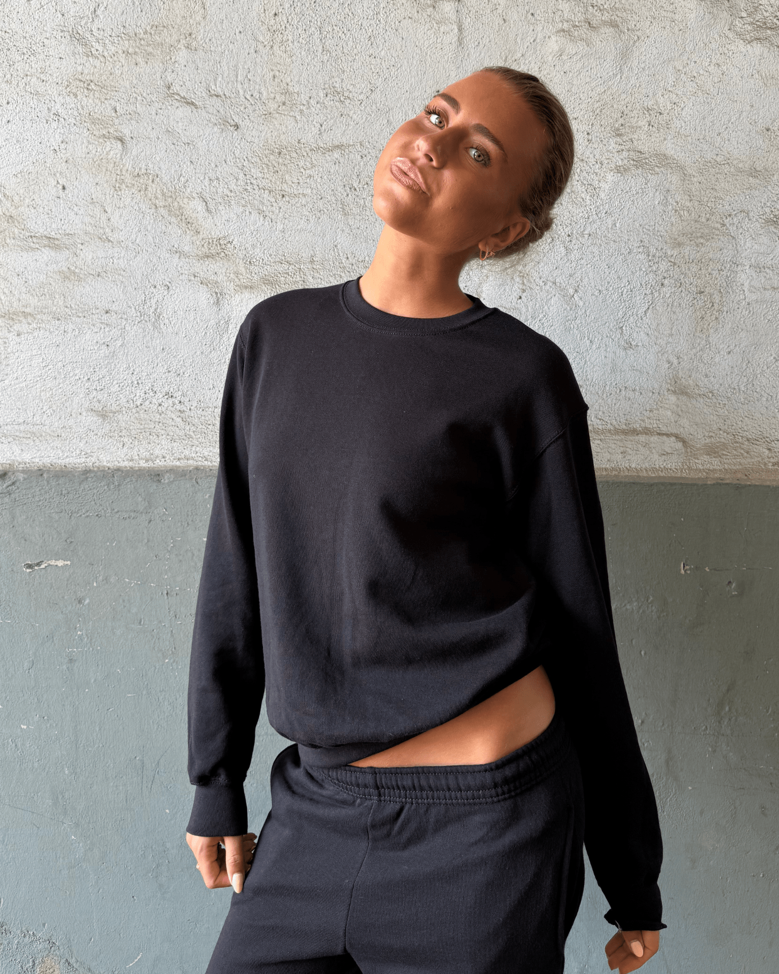 Kvinde i sort Fruit sweatshirt og matchende joggingbukser
