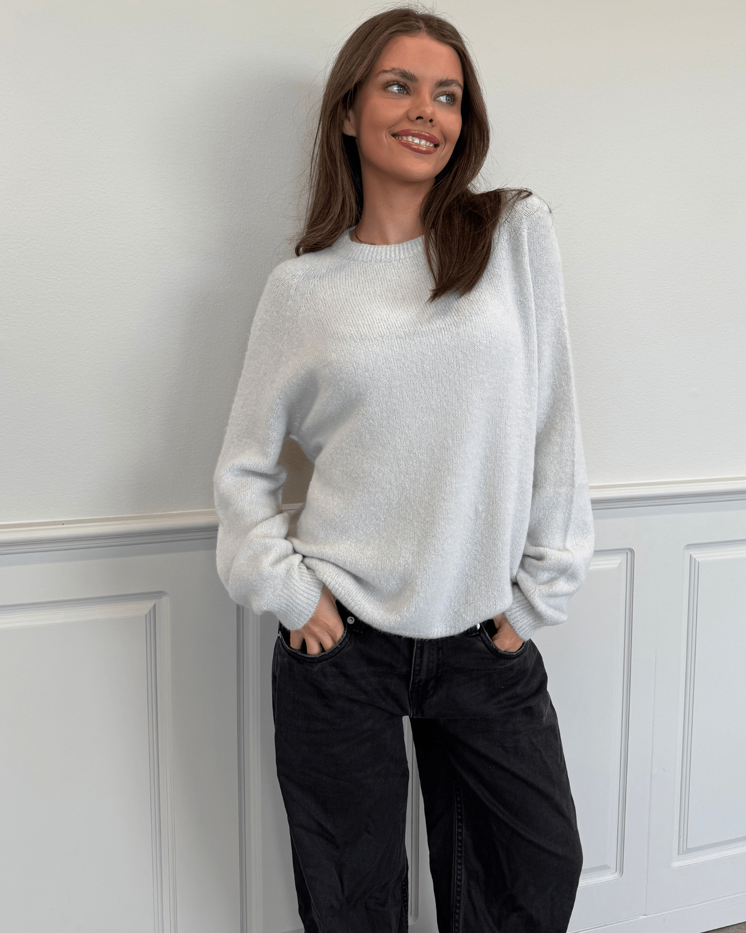 Model i lysegrå Molli striktrøje og mørke jeans