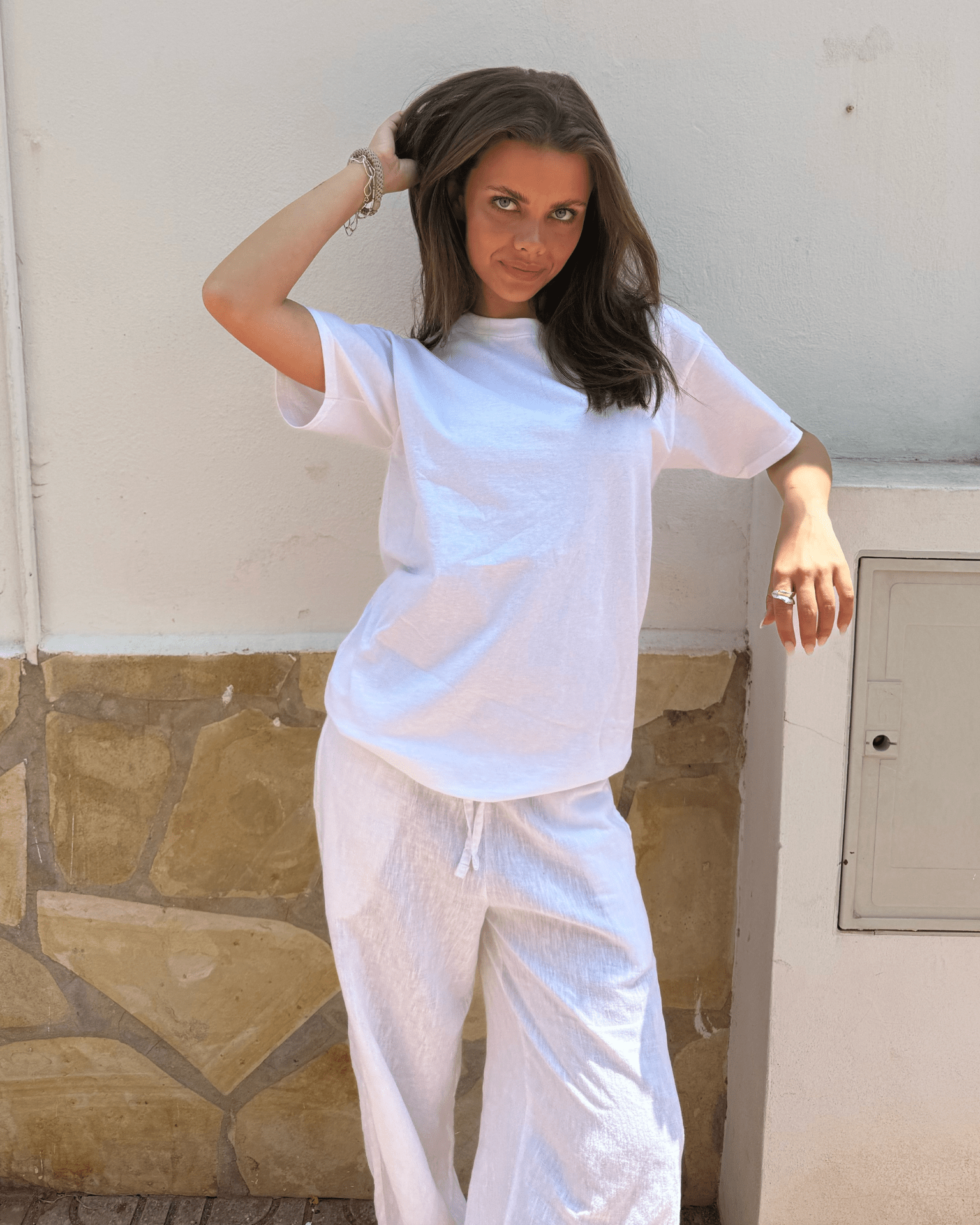 Model i hvid Fruit of the Loom t-shirt i bomuld og matchende hvide bukser