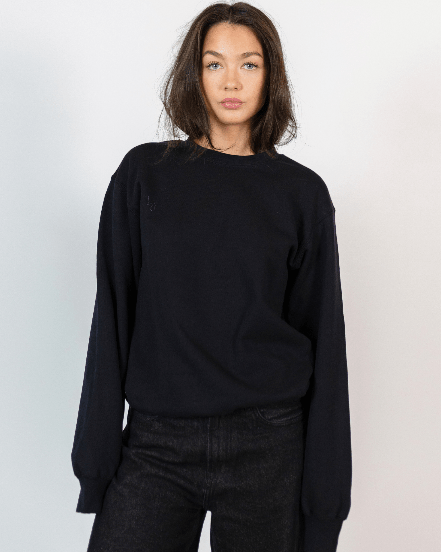 Kvinde i sort Fruit sweatshirt med rund hals og mørke jeans