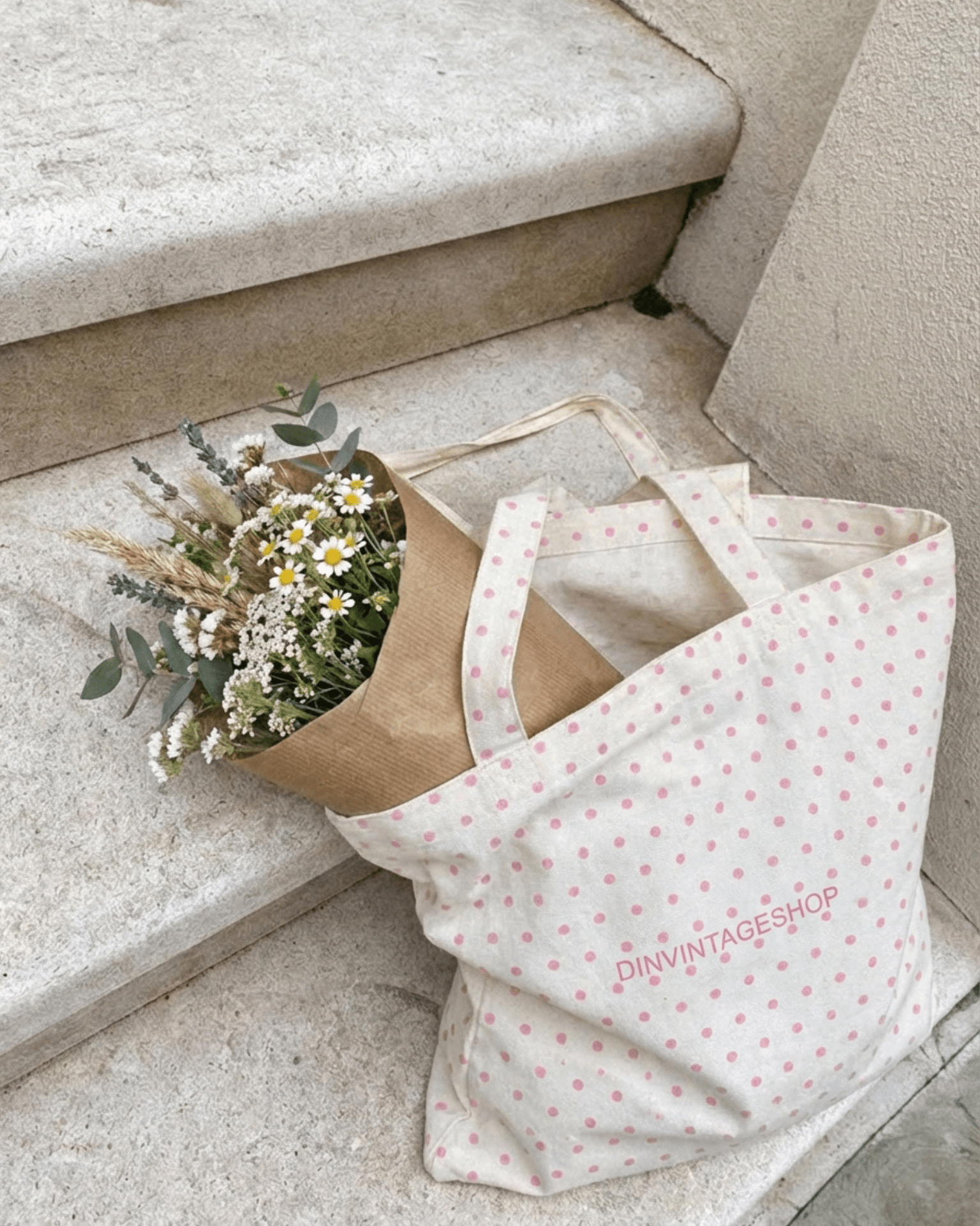 Hvidt stofnet med lyserøde prikker og blomsterbuket på en trappe