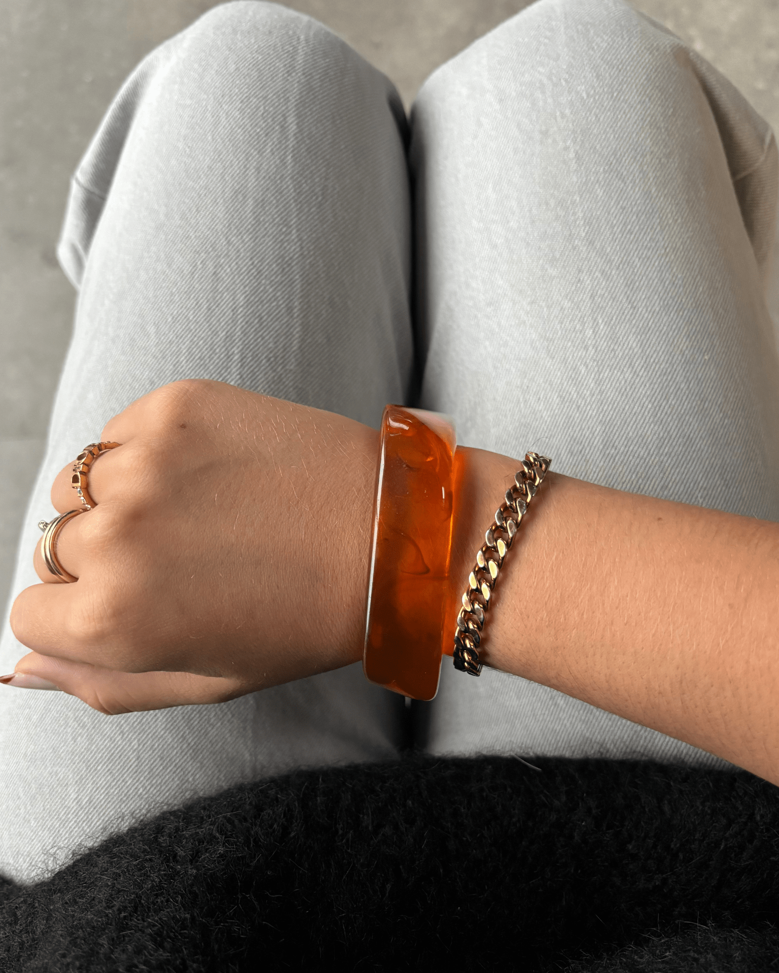 Chunky ravfarvet Amber armbånd i akryl på håndled med guldarmbånd
