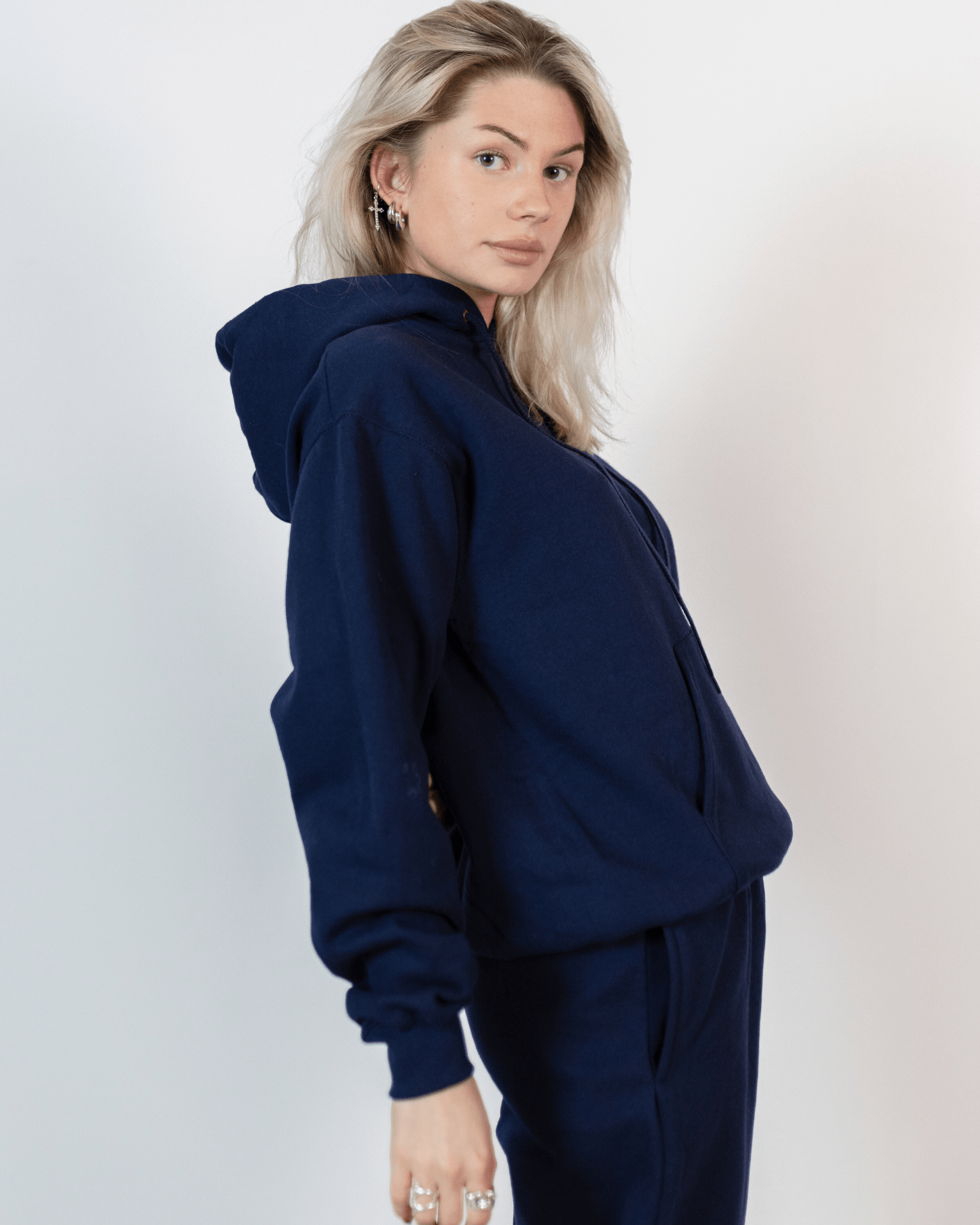 Model i mørkeblå Fruit Hoodie og matchende joggingbukser set fra siden