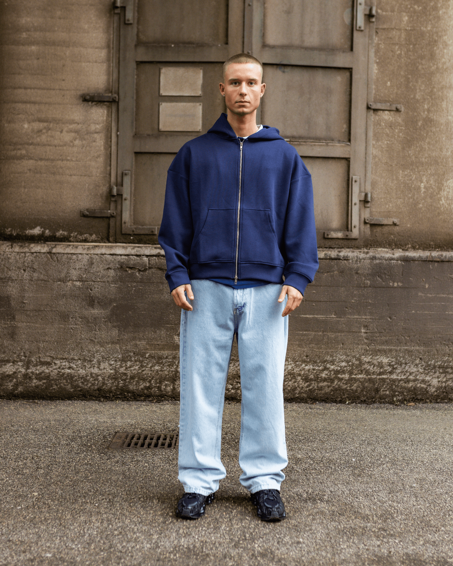 Model i mørkeblå hættetrøje og lyseblå Tyler baggy jeans med lav talje