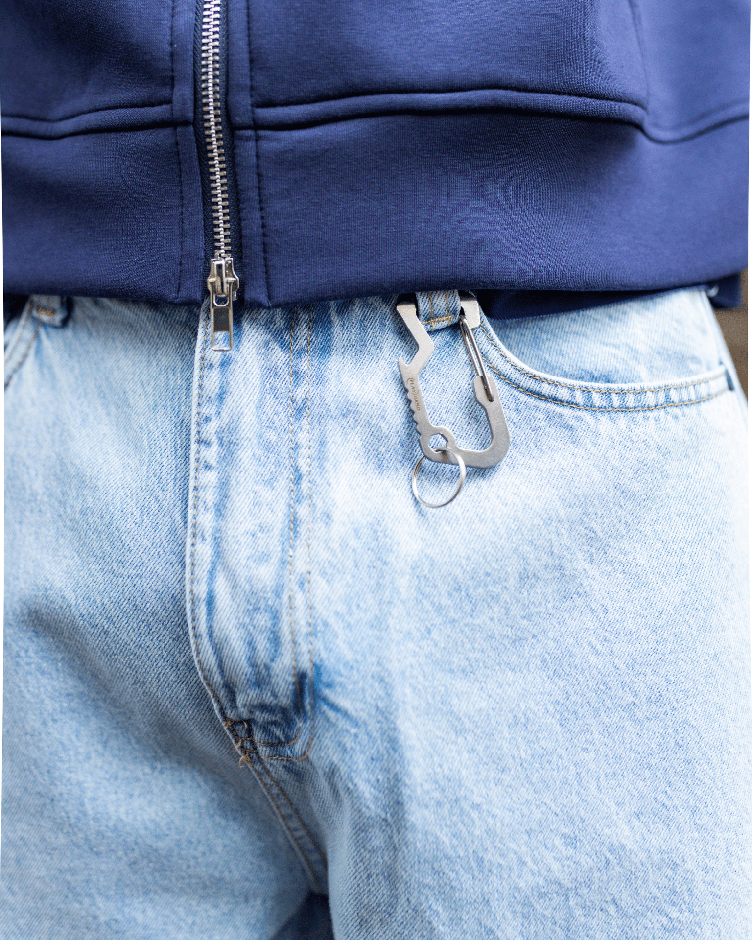Nærbillede af lyseblå Tyler baggy jeans i bomuld med en metalclip i bæltestroppen.