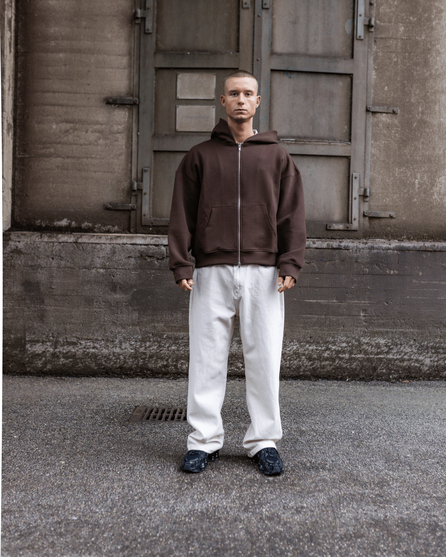 Mand i brun hættetrøje og Tyler baggy jeans i off white bomuld med lav talje.