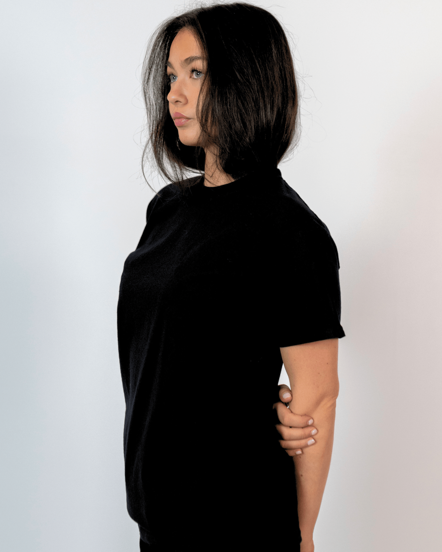 Kvinde i sort Fruit of the Loom t-shirt af blød bomuld set fra siden