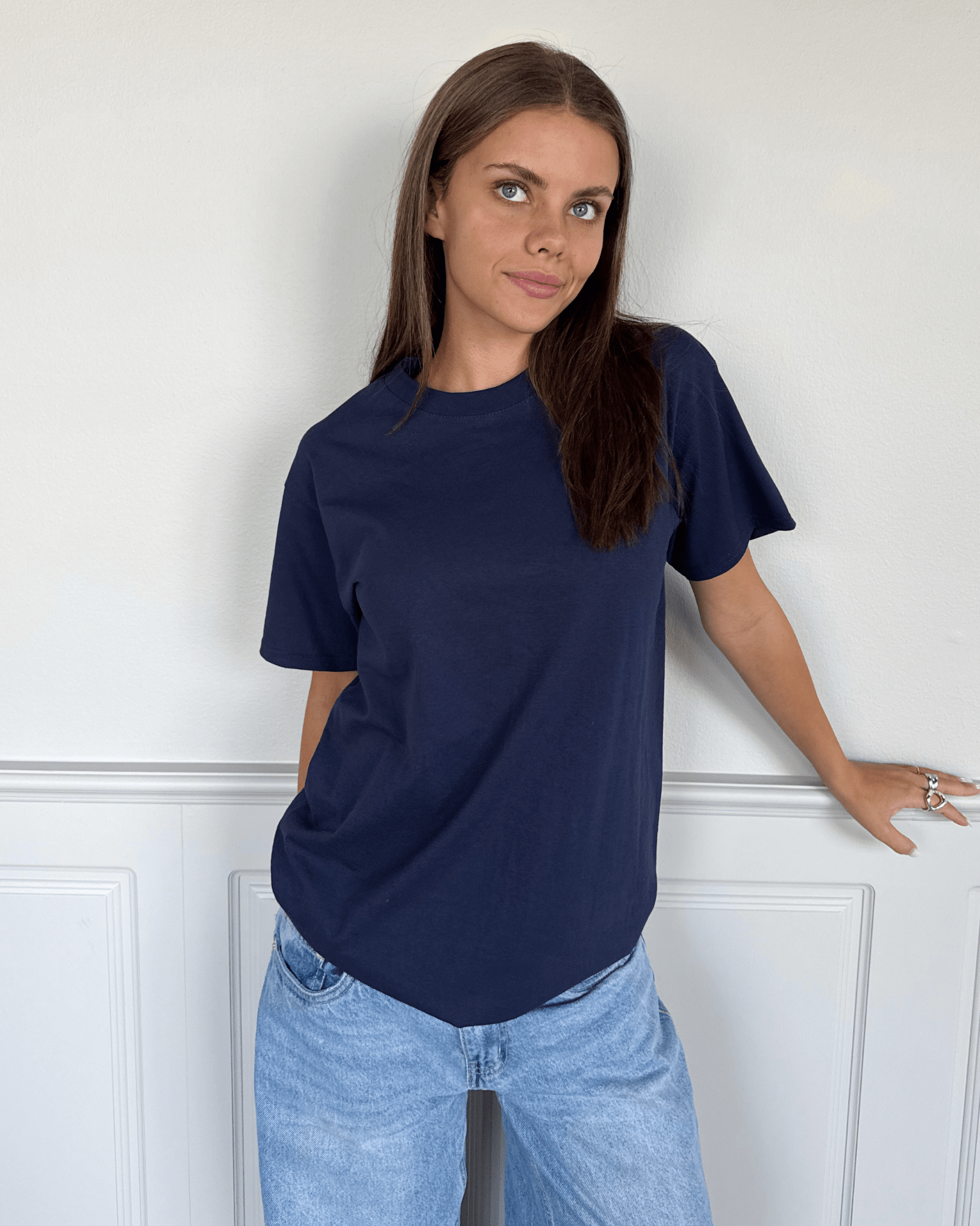 Kvinde i navyblå Fruit of the Loom t-shirt i bomuld og lyse jeans