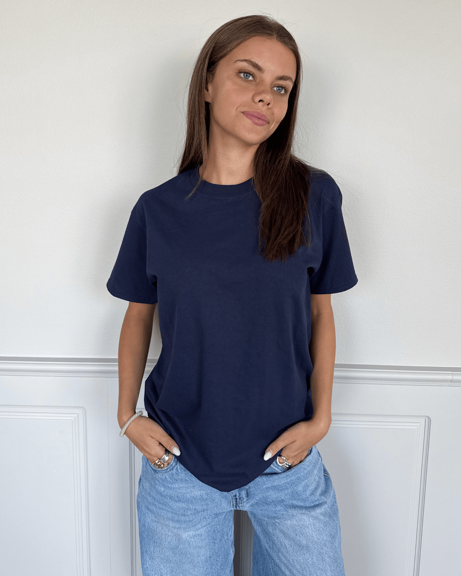 Kvinde i navyblå Fruit of the Loom t-shirt i bomuld og lyse jeans