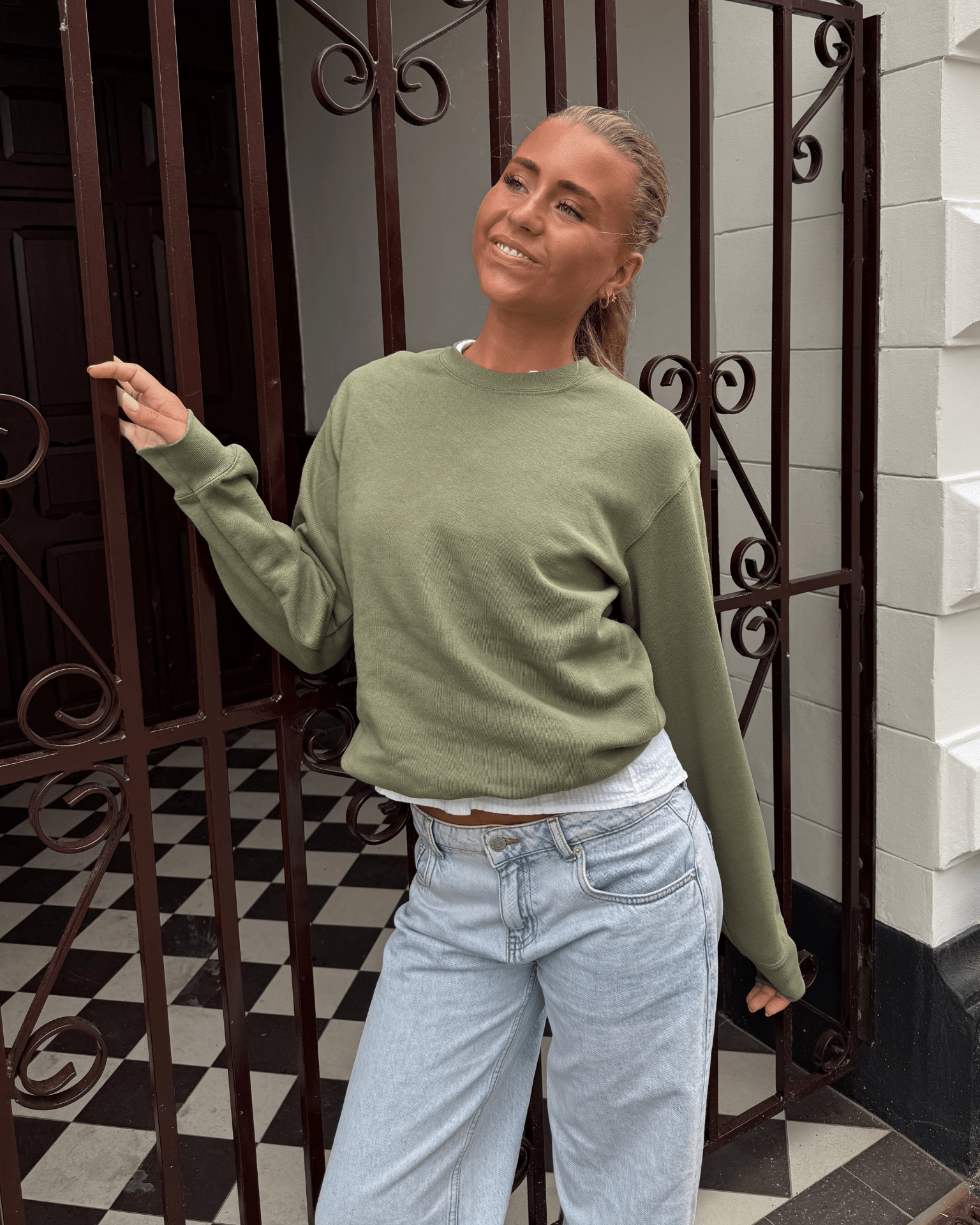 Olivengrøn sweatshirt i bomuld og polyester på model med lyse jeans