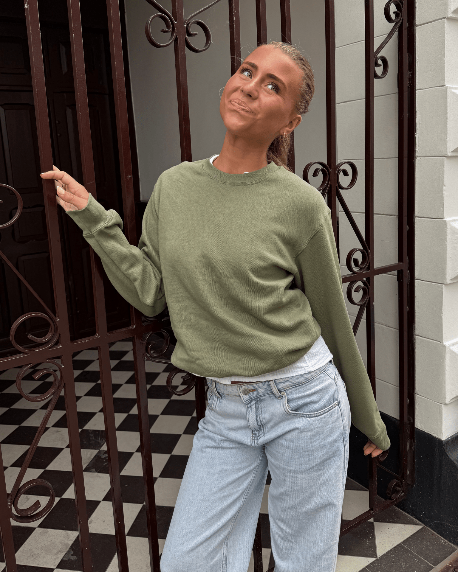 Olivenfarvet sweatshirt i bomuldsblanding på model med lyse jeans