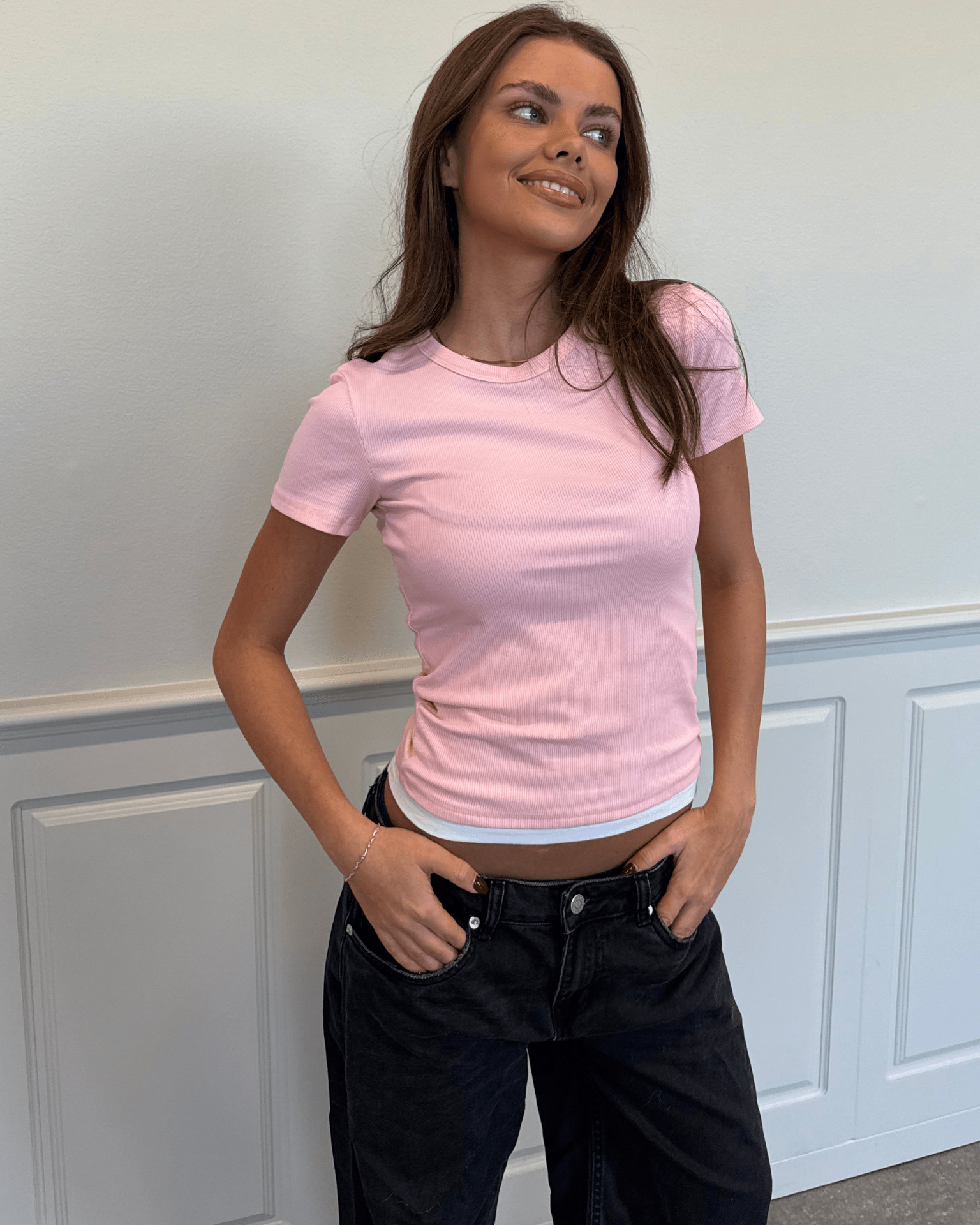 Tætsiddende, lyserød ribbet T-shirt med rund hals og korte ærmer fra Din Vintage Shop.