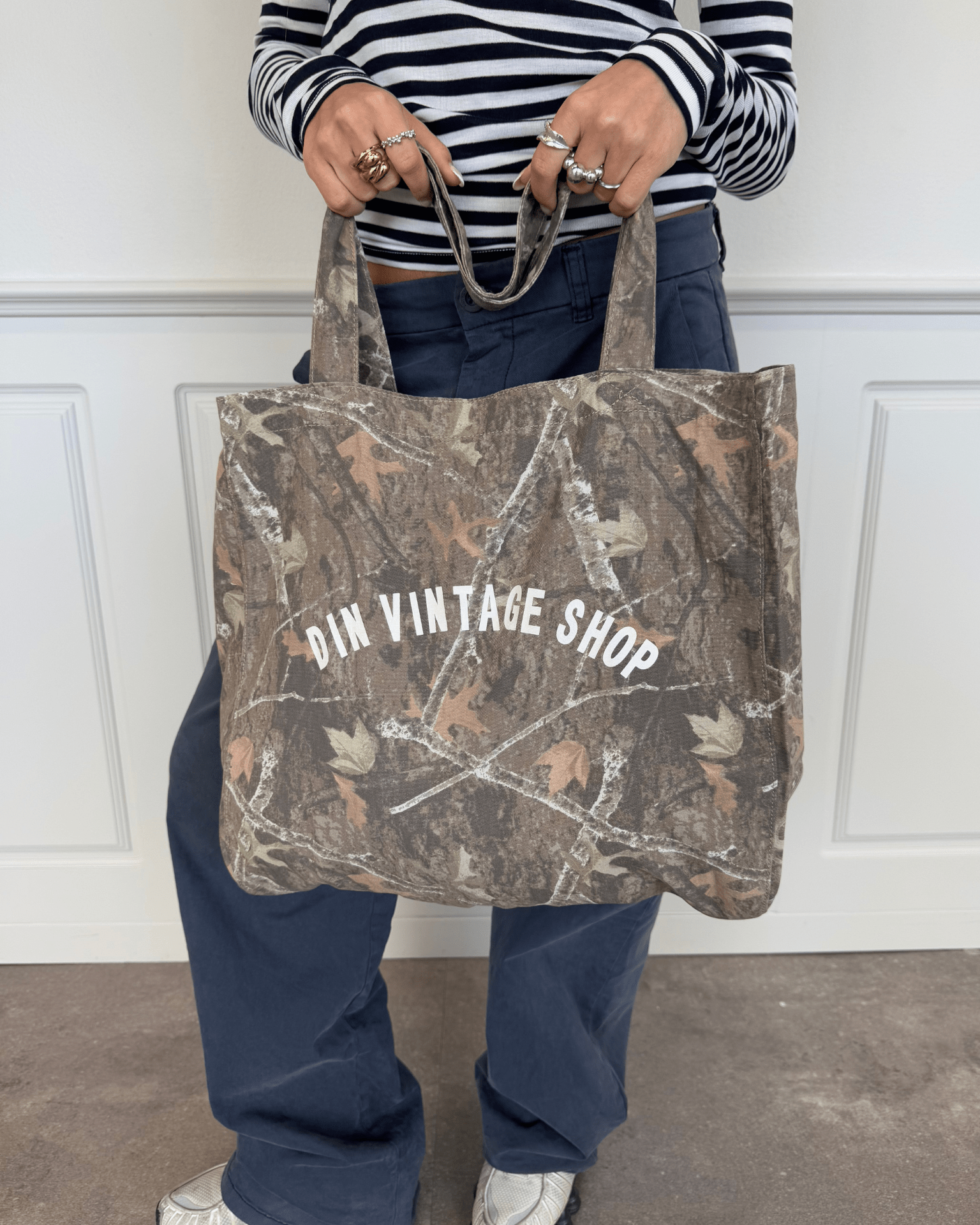 Grøn camouflage-totebag i stof med hvidt Din Vintage Shop-logo.
