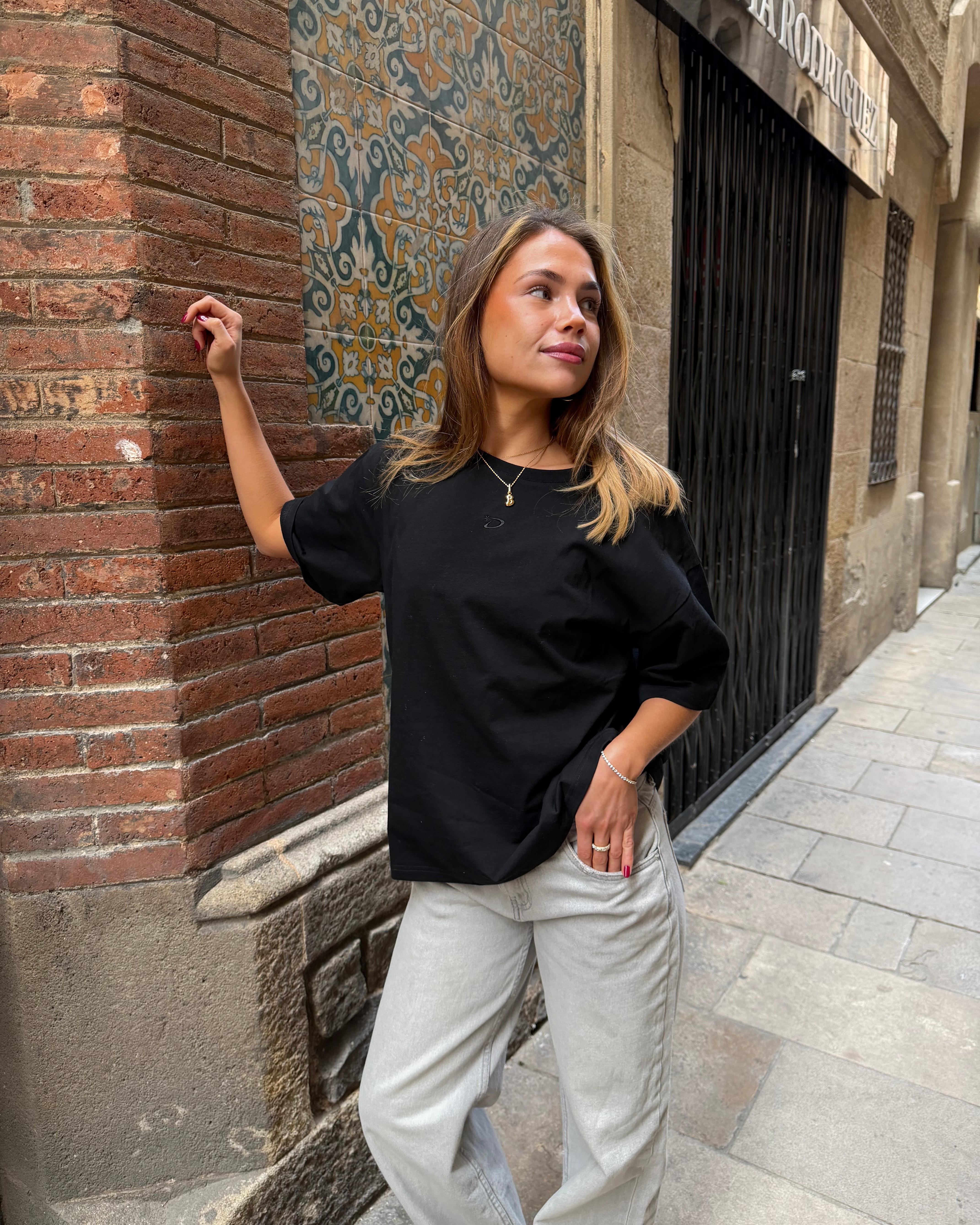 Kvinde i sort ACE boxfit t-shirt i bomuld og lyse jeans på gaden
