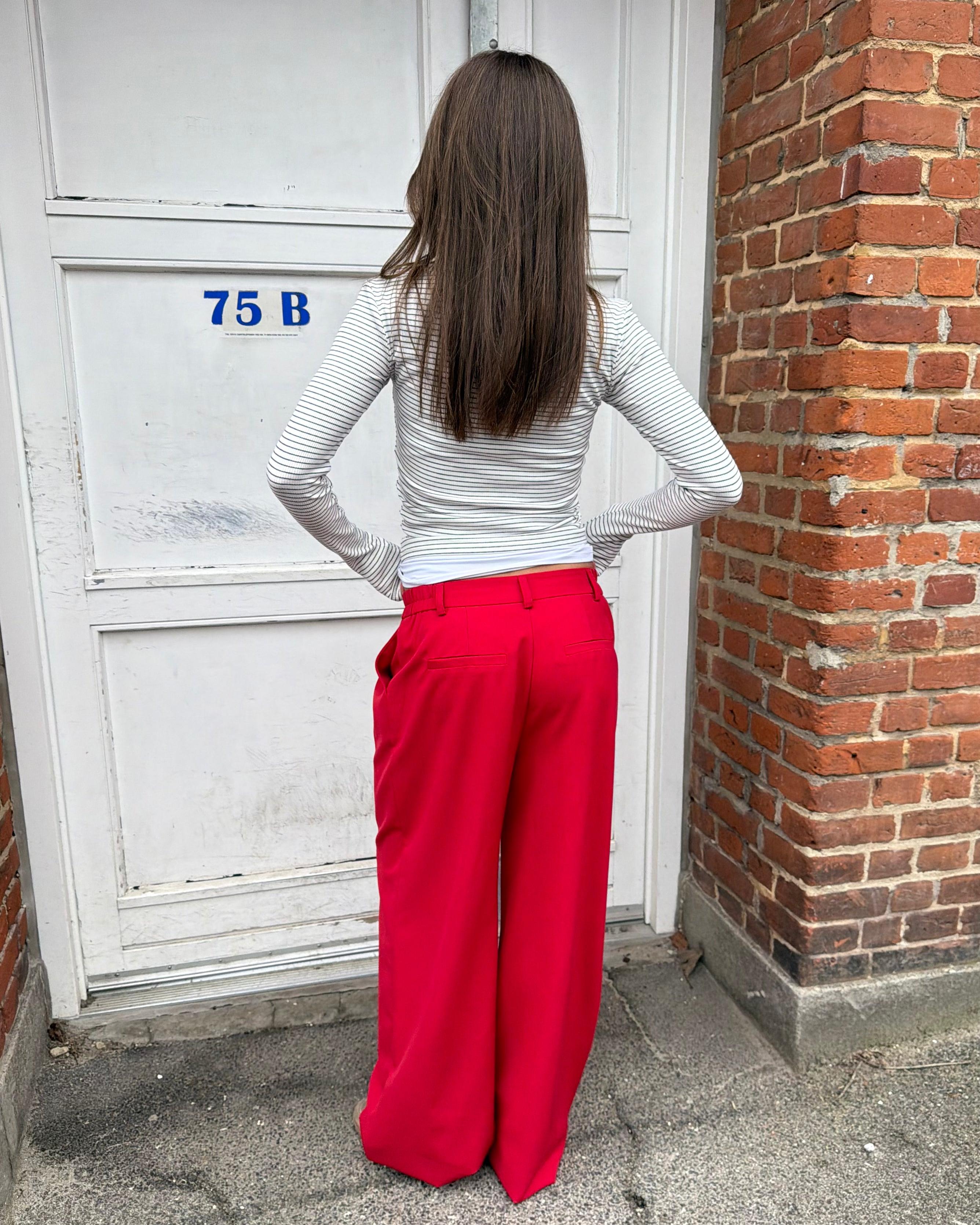 Røde, løstsiddende og baggy suit pants set bagfra på en model