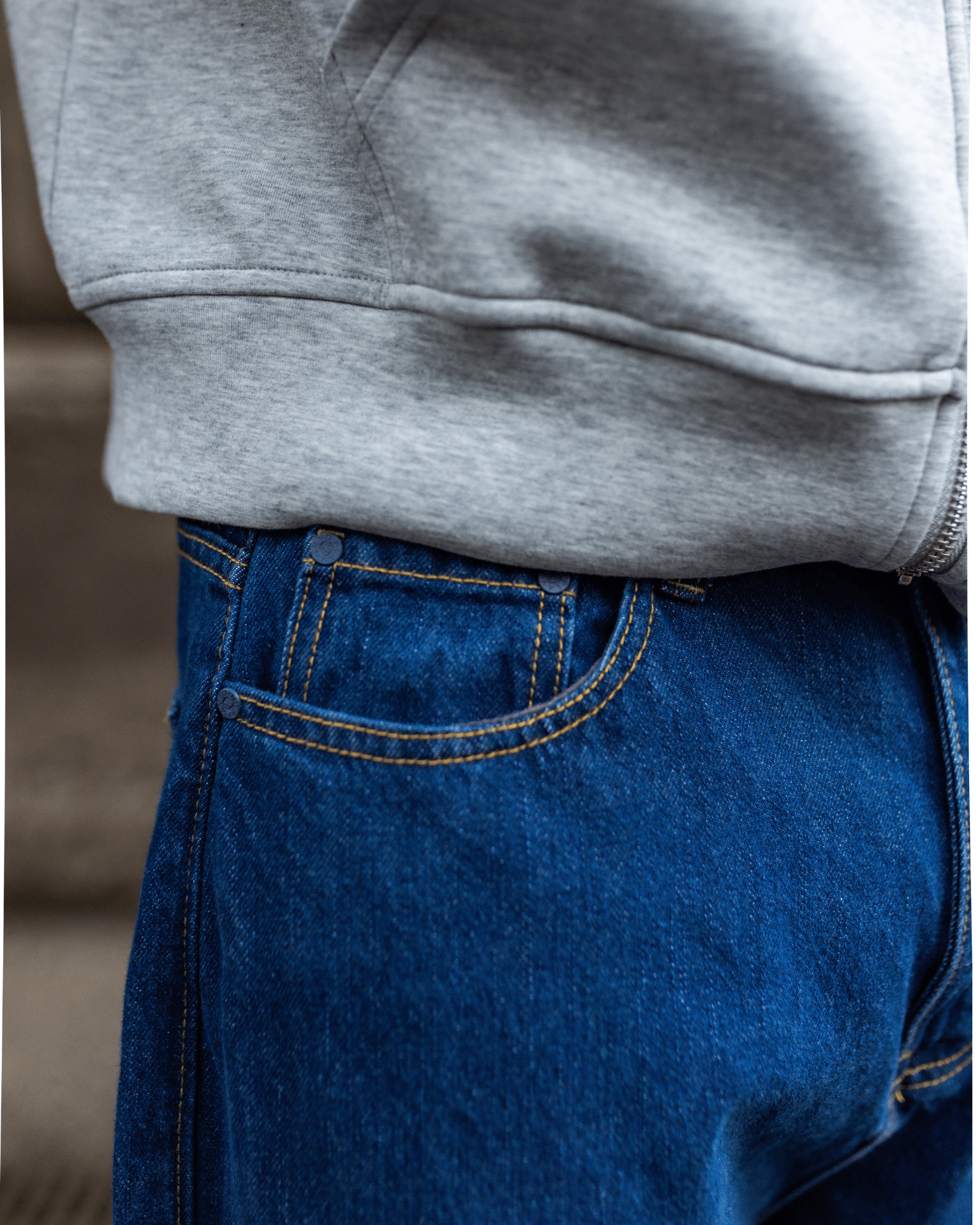 Nærbillede af mørkeblå Tyler baggy jeans i bomuld med gule syninger og lommedetalje