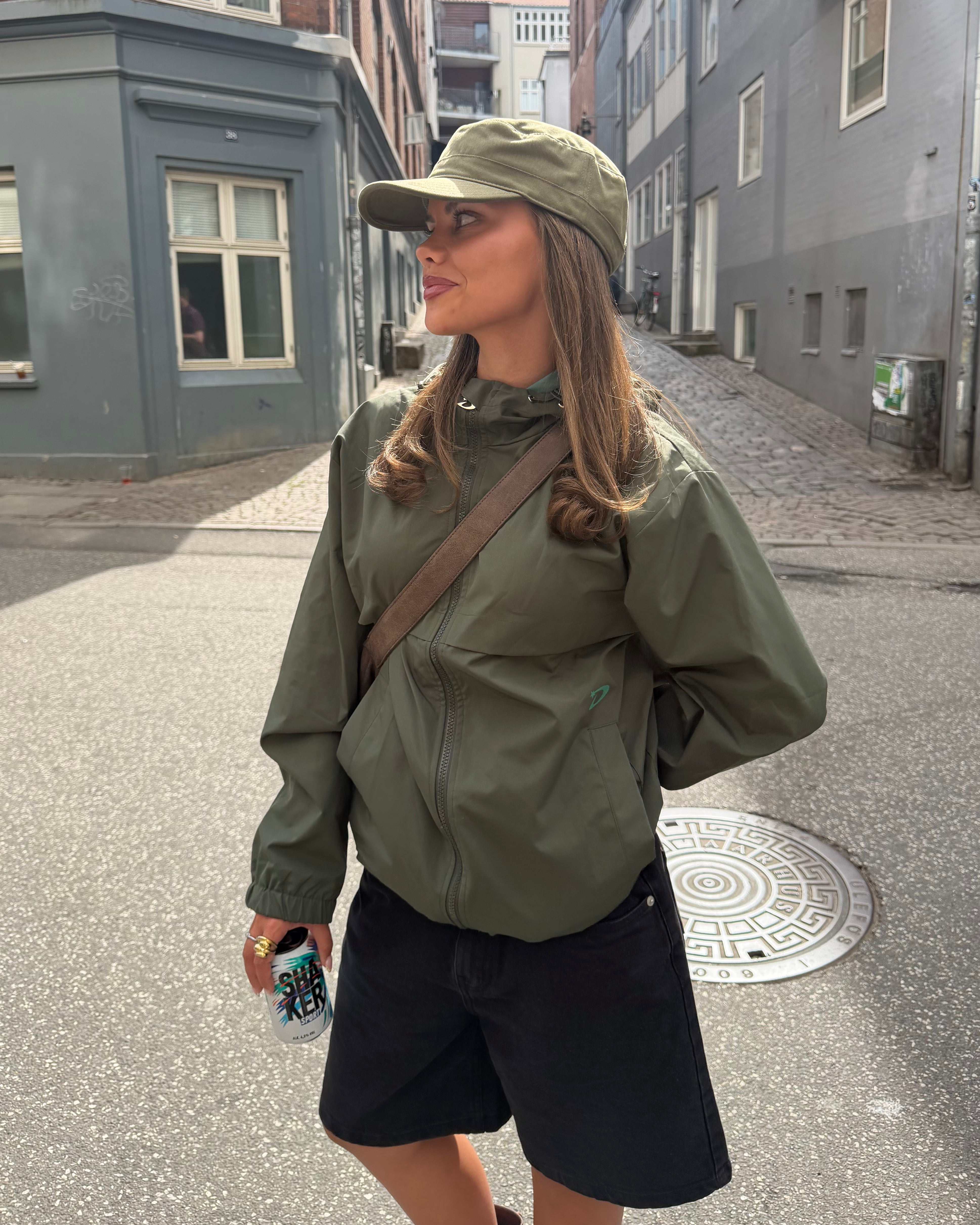 Kvinde med olivengrøn army cap i blød bomuld på gaden